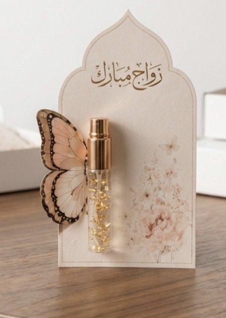 عطر مع بطاقة زخرفة وجناح فراشة